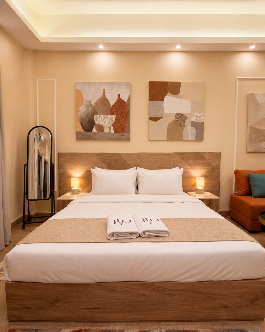 King bed framed by abstract artwork and warm bedside lighting