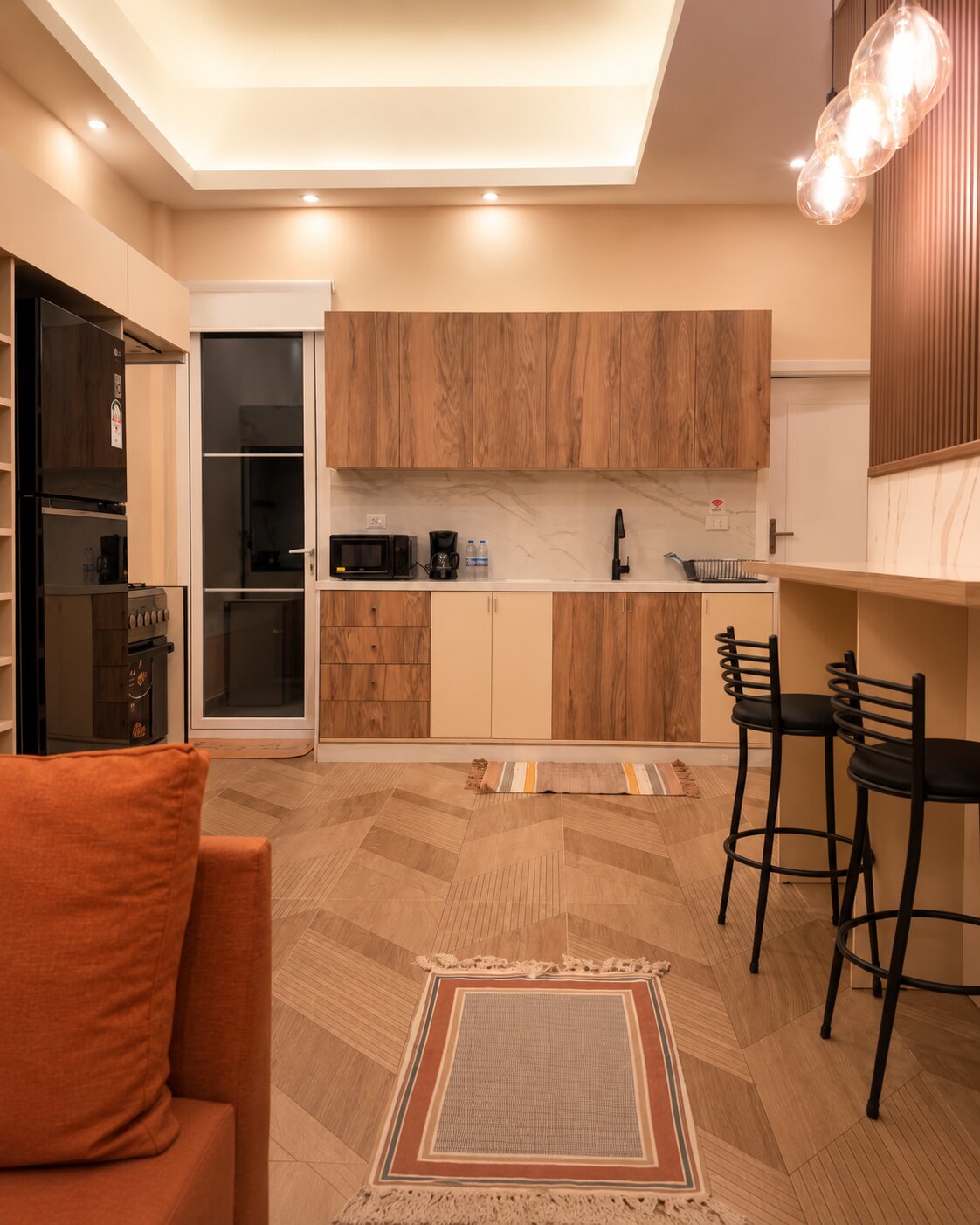 Full kitchen with walnut cabinetry and marble splashback